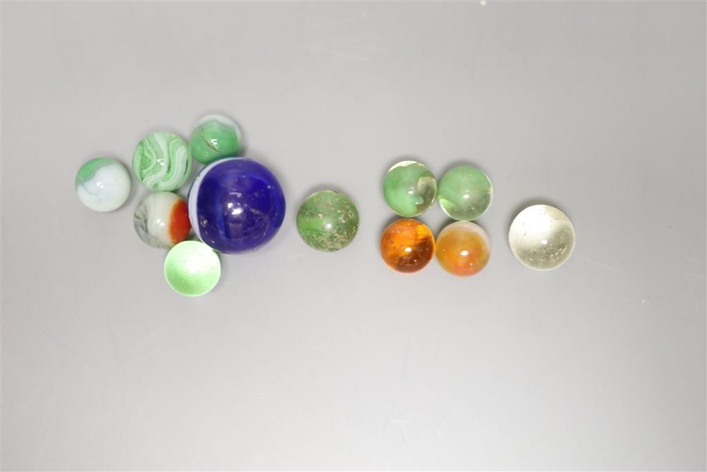 A large Victorian glass marble and eleven smaller marbles